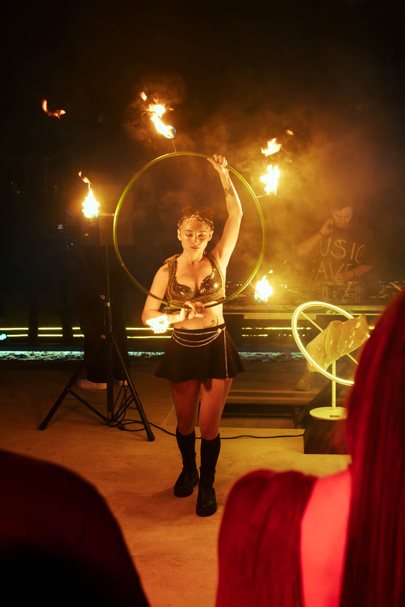Artista con hula hoop de fuego en el patio de Nebulae